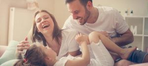 Family enjoying quality time indoors, laughing and playing together, emphasizing the importance of good indoor air quality for health and comfort.