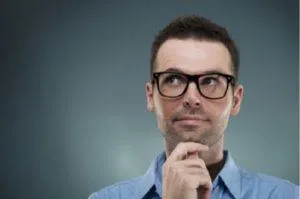 Man in glasses thoughtfully considering options for heat pump systems, reflecting on tips for winter heating efficiency.