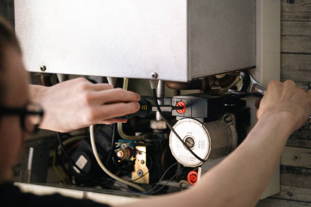 Technician repairing a furnace, adjusting components with tools, ensuring efficient operation for home heating in Modesto, CA.
