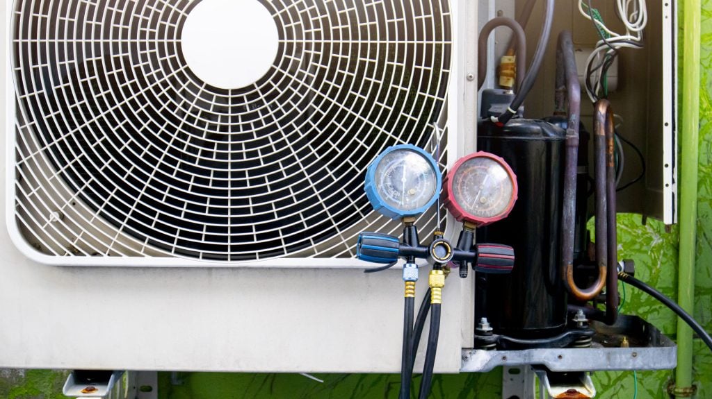 Pressure gauges connected to a condenser during a commercial HVAC repair diagnostic in Modesto, CA