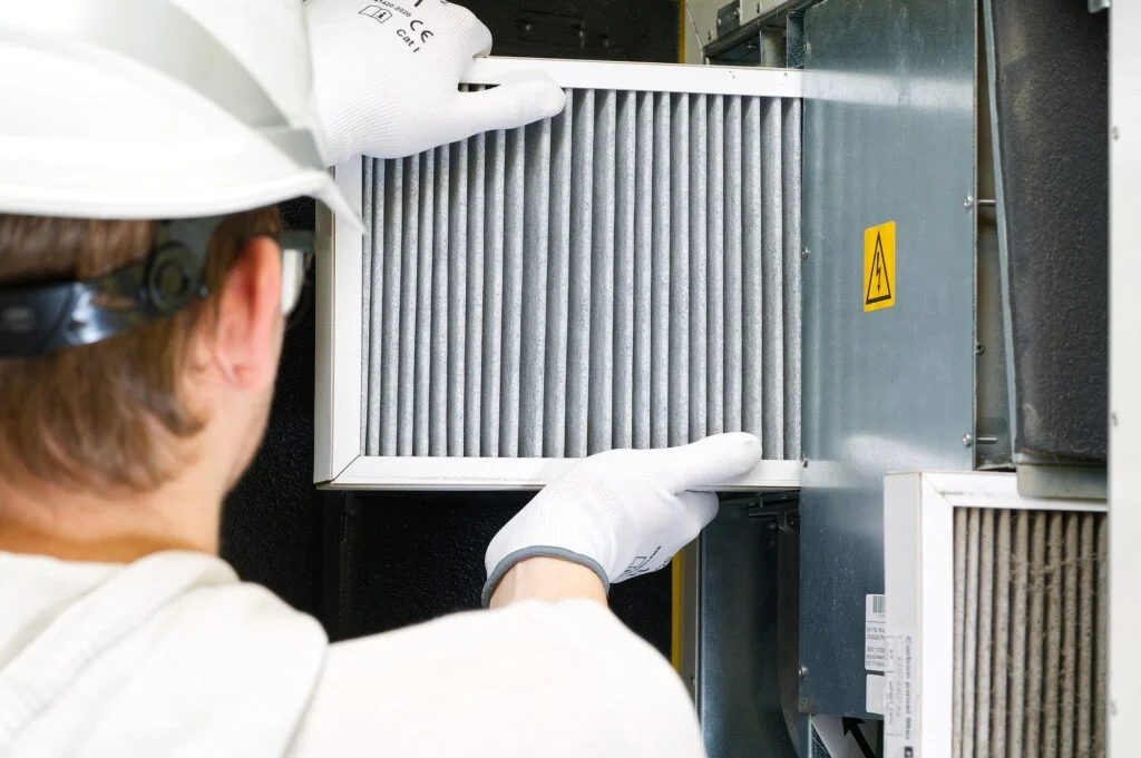 Technician changing a furnace air filter, indoor air quality service in Hughson, CA